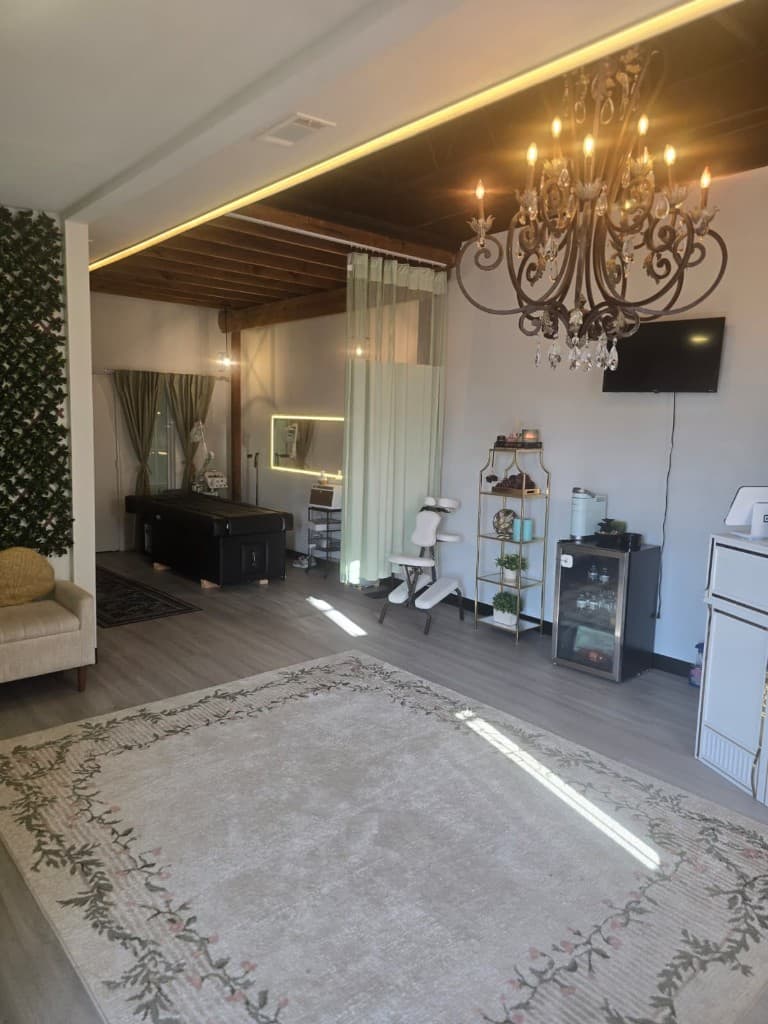 Full studio interior with treatment area and chandelier